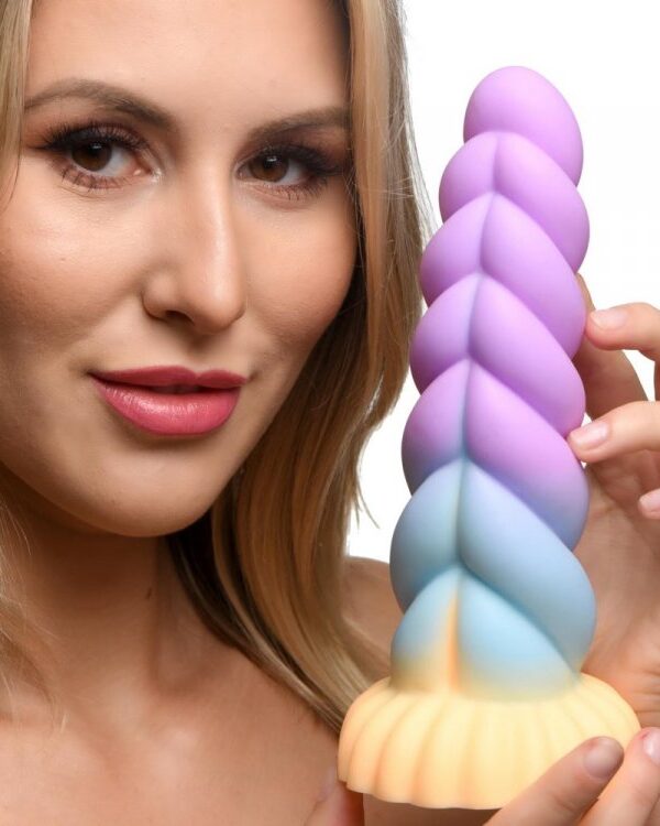 Woman holding the Mystique unicorn dildo to show its size