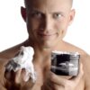 Model holding an open jar of Invade deep fisting cream