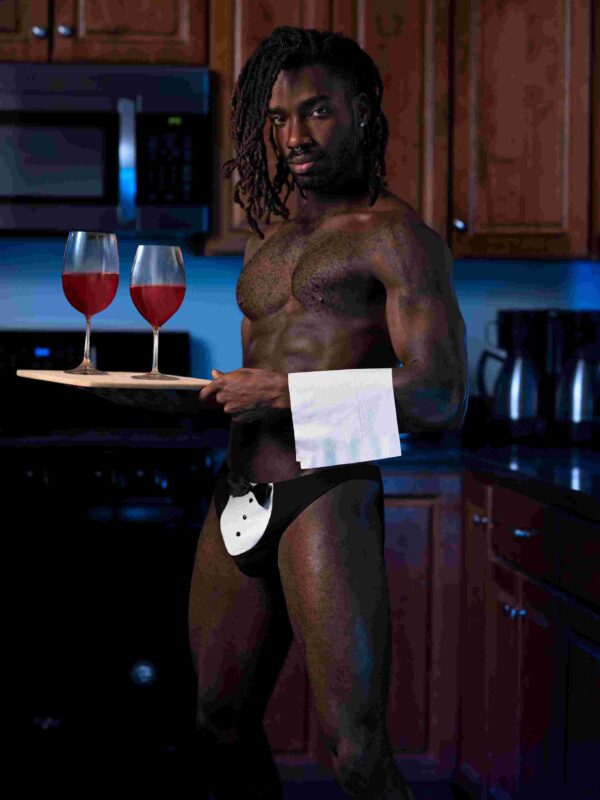 Model in the tuxedo thong holding a serving tray