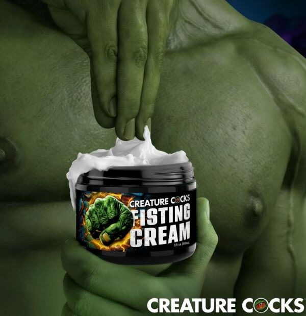 Green creature hand scooping Creature Cocks Fisting Cream from the jar