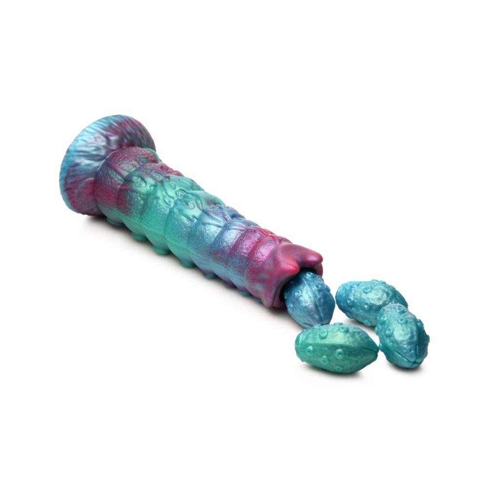 Galactic Breeder ovipositor on its side with 4 silicone eggs spilling from the tip