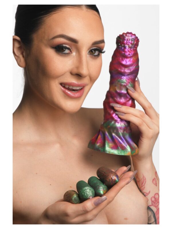 Woman holding the Larva ovipositor dildo and its silicone eggs to show their size