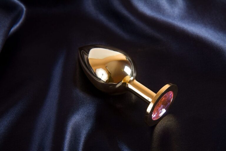 Gold jeweled butt plug on satin